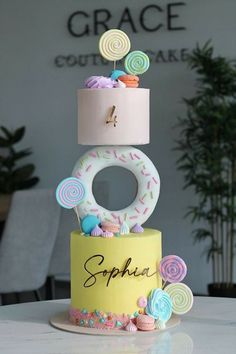 a three tiered cake decorated with donuts and sprinkles on top