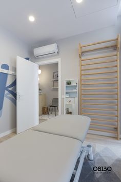 two white beds sitting in a room next to a wall mounted air conditioner on the wall