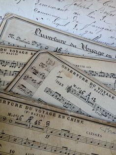 old sheet music tags are laying on top of each other with musical notations printed on them