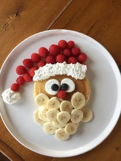 a white plate topped with fruit and a face made to look like a man's face