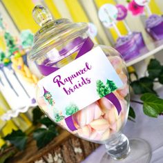 a glass jar filled with candy sitting on top of a table