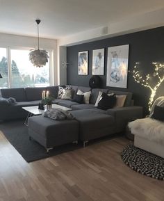 a living room filled with furniture next to a window covered in christmas lights and decorations