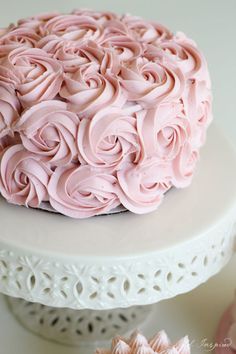 a cake with pink frosting sitting on top of a white plate