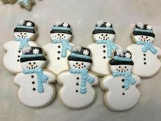 decorated cookies with frosting on top of each other in the shape of snowmen