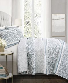 a bed with blue and white comforters in a bedroom