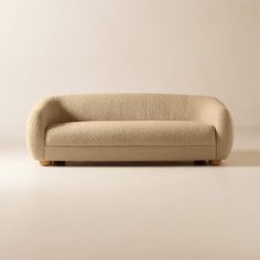 a beige couch sitting on top of a white floor