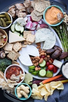 a platter filled with cheese, crackers, and veggies is shown