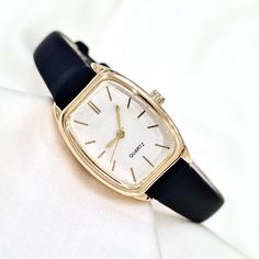 Woman Wrist Watch, Gold Colour Watch, Stick Numeral Dial, Rectangle Design Watch, Modern Design Watch, Easy Adjustable Band, White Dail, Black Faux Leather Band,  Gift for Her, Mother's Day Gift, Valentine's Day Gift, Present for Her, Daily Usage Diamensions: - Case Thickness: 10 mm - Total Lenght: 22,5 cm - Case Diameter: 27 mm x 22 mm - Weight: 35 gr Rectangular Quartz Watch For Everyday Use, Timeless Rectangular Watch With Adjustable Fit, Timeless Adjustable Rectangular Watch, Adjustable Watch With Rectangular Dial, Everyday Black Rectangular Watch Accessories, Classic Black Square Watch, Classic Black Square Watches, Black Rectangular Analog Watch, Elegant Black Square Watch