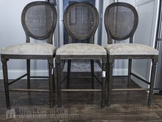 two chairs sitting next to each other on top of a wooden floor in front of a door