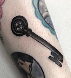 a close up of a person's arm with a key tattoo on it