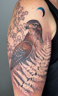 a man with a tattoo on his arm has a bird and flowers in the background