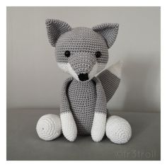 a crocheted stuffed animal sitting on top of a gray table next to a white wall