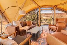 the inside of a tent with couches and chairs