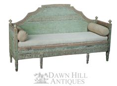 an old wooden bench with two pillows on it's back and the seat upholstered