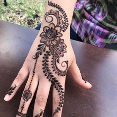 a woman's hand with hennap on it and flowers painted on the palm