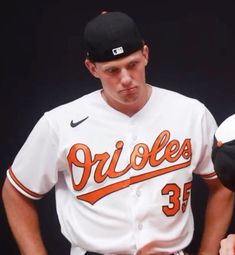 a baseball player holding a bat and wearing a uniform