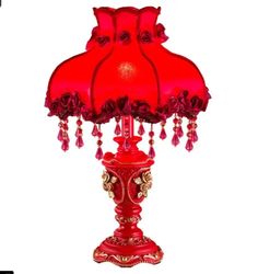 a red table lamp with roses on it