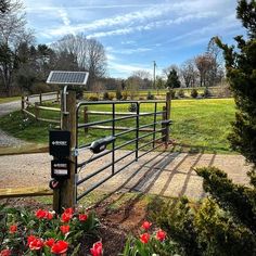 a fenced in area with flowers and a solar panel on the top of it