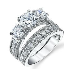 three stone engagement ring set with round diamonds on the sides and two rows of pave stones