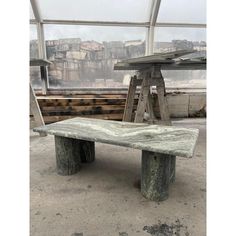 a stone bench sitting in front of a window