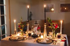 the table is set with candles and plates