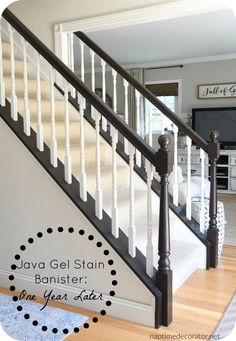 a white staircase with black handrails in a living room next to a tv