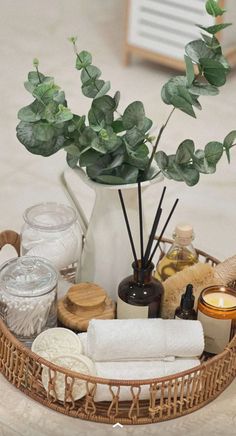 a wicker basket with candles, soaps and other items in it on a table