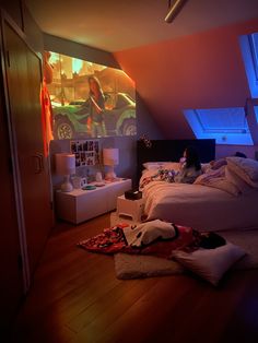 a woman laying on top of a bed in a bedroom next to a wall mounted projector