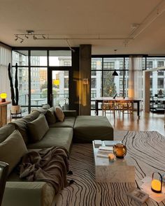 a living room filled with furniture and lots of windows next to a dining room table