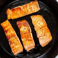 three pieces of fish cooking in a skillet