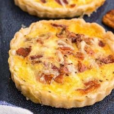 two quiche pies sitting on top of a baking sheet