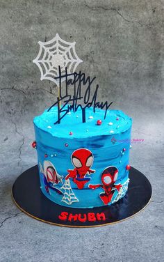 a blue birthday cake with spiderman on it