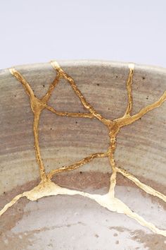 a close up of a bowl with gold paint on the inside and outside of it