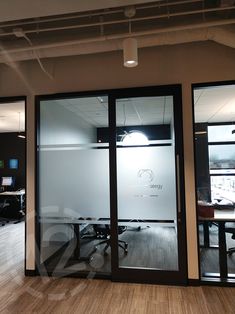 an office with glass walls and wooden floors