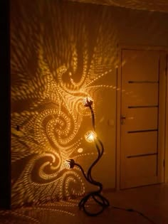 a room with a light shining on the wall and a lamp in front of it