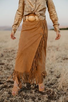 This fringed, flowing skirt pays tribute to Lily’s ties to Nevada. With a touch of Western elegance, it captures the beauty of the landscapes that inspired it. Perfect for cowgirls who blend heritage with high fashion, this skirt moves with you, just like the wind over the Nevada sagebrush. True to Size Little to Medium Stretch Faux Suede Fringe Detailing Ankle Length Skirt Bohemian Asymmetrical Skirt For Fall, Bohemian Asymmetrical Maxi Skirt For Fall, Fall Festival Fringe Skirt, Bohemian Brown Bottoms With Fringe, Bohemian Brown Fringe Bottoms, Bohemian Fringed Bottoms For Fall, Bohemian Fringe Bottoms For Fall, Nevada Sagebrush, Ankle Length Skirt