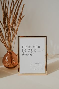 a sign sitting on top of a table next to a vase filled with dry grass