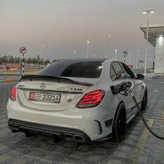 a mercedes benz is plugged into an electric car at a gas station in qatar