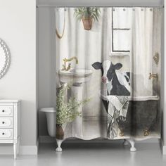 a shower curtain with a black and white cow in a bathroom