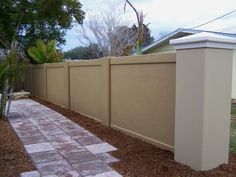 a white fence next to a brick walkway