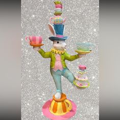 a figurine of a rabbit holding a cake and teacup on a plate