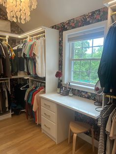 an organized closet with clothes, shoes and other items on the shelves in front of a window