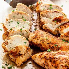 sliced chicken on a cutting board next to a knife