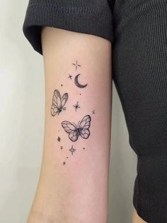 a woman's arm with butterflies and stars on it