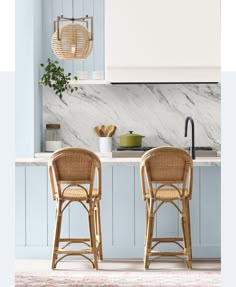 two wicker bar stools sit in front of a kitchen island with marble counter tops