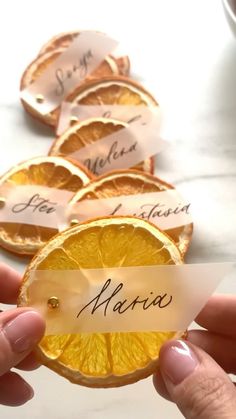 a person holding an orange slice with name tags on it