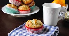 two muffins sitting on top of a table next to a cup