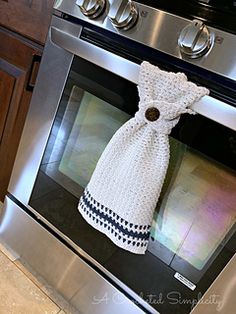 a kitchen stove with an oven mitt wrapped in a towel