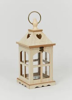 a small wooden lantern with a heart on the top