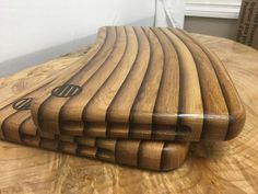 a wooden cutting board sitting on top of a table next to a knife holder and box